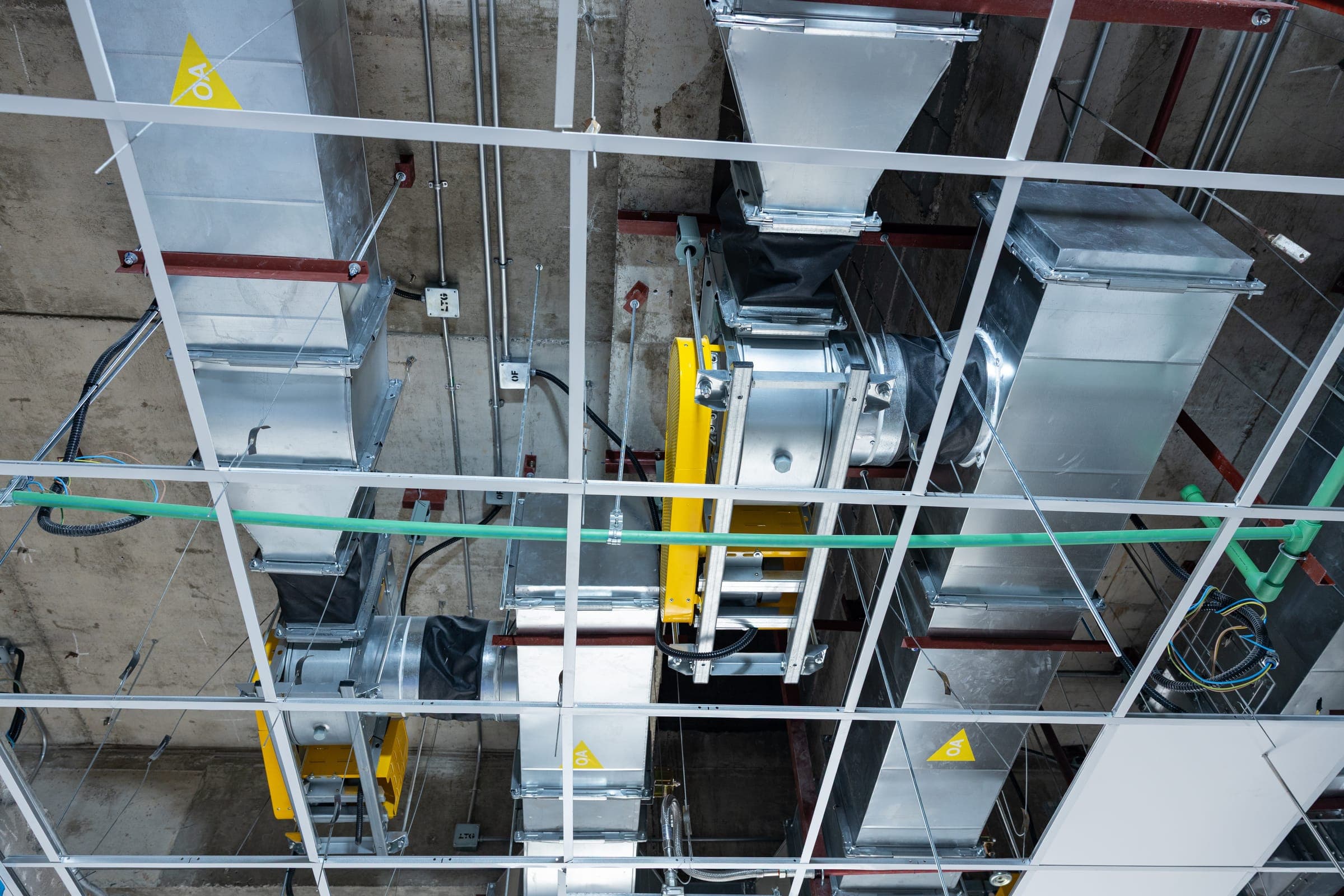 Rectangular ductwork and supporting steelwork being installed in an exposed soffit before ceilings are closed in.