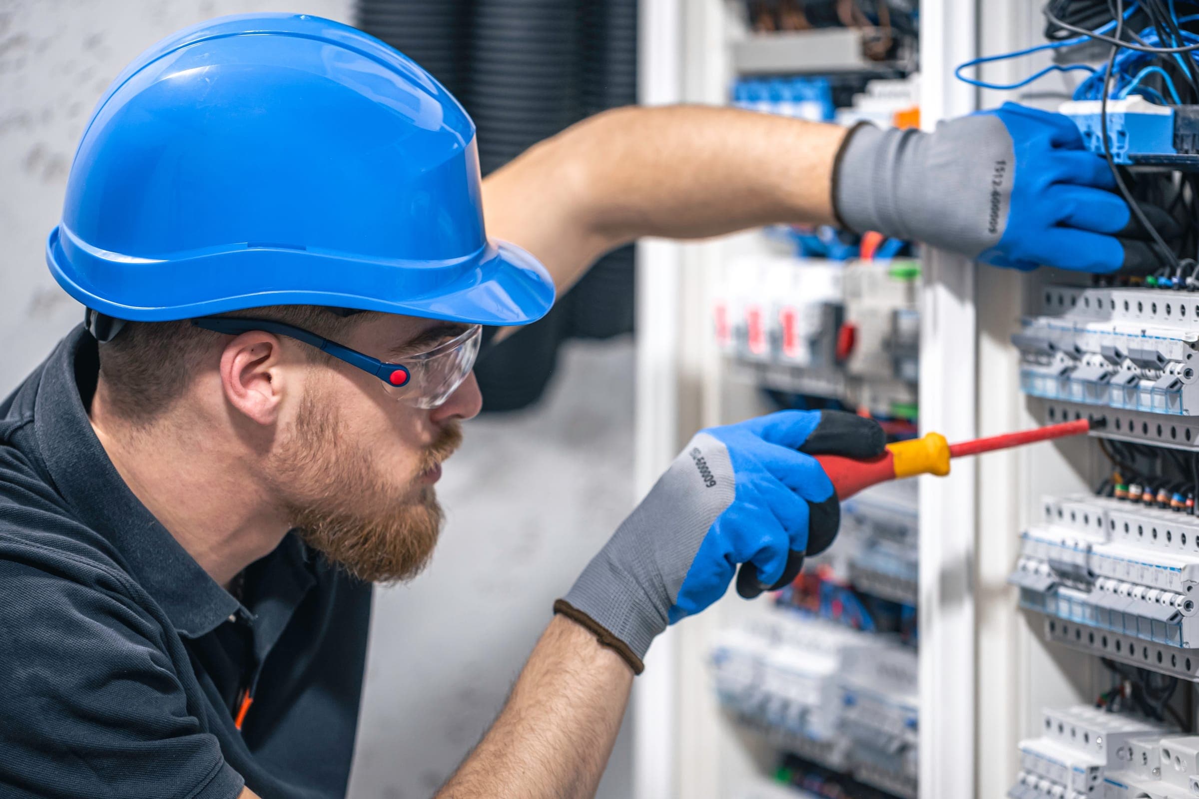 An electrician terminating conductors inside a distribution board.